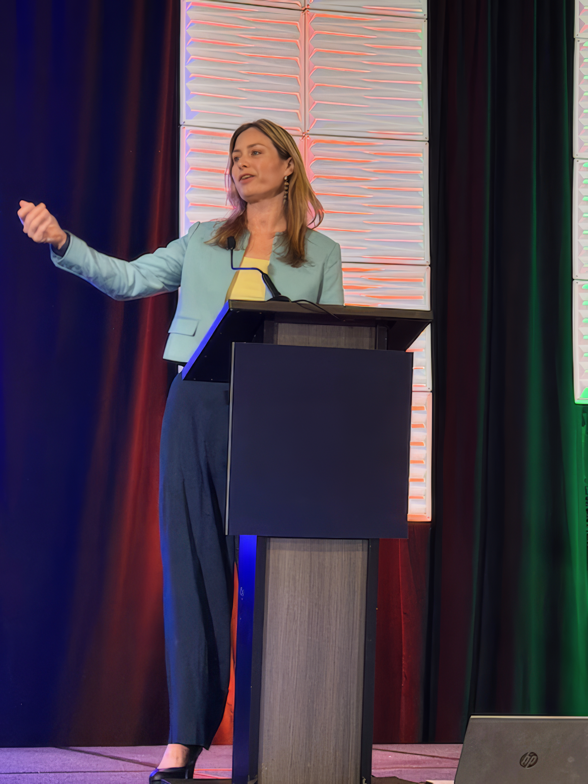 Holly Forman-Patel speaking at a conference podium